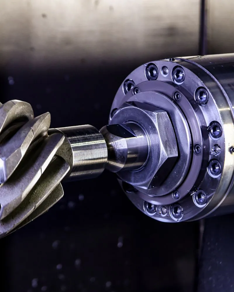 Brazo robótico en centro de mecanizado CNC procesando perfiles de aluminio con tolerancias milimétricas a partir de datos CAD.
